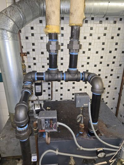 Black iron boiler-room piping with insulated risers.