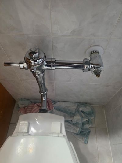 Commercial flush valve replacement on a chrome supply.