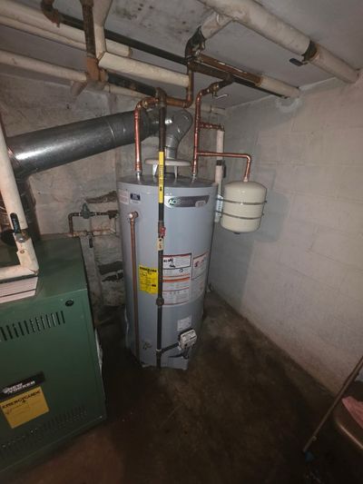 AO Smith water heater installation with copper supply lines and adjoining boiler — full residential basement plumbing system.